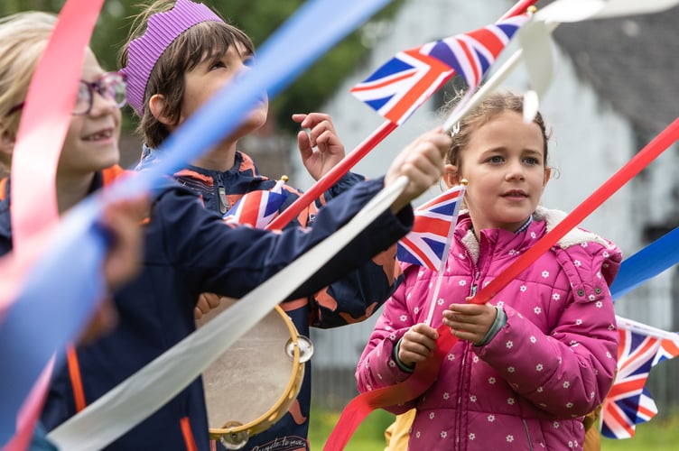 Primary school children from Templeton Community Primary School, Narberth, Pembrokeshire, kick off their Platinum Jubilee celebrations with a colourful parade through the village, waving flags and singing, whilst dressed in their decorated gold crowns and iconic red buses. The children danced a maypole on the village green with red, blue and white ribbons for the onlooking residents, as well as created Platinum Jubilee mosaics which will now remain a permanent fixture in the village.