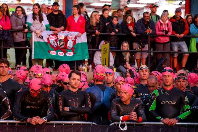 TENBY, WALES - SEPTEMBER 11:  Athletes and spectators observe a minutes silence for the Queen ahead of IRONMAN Wales on September 11, 2022 in Tenby, United Kingdom. (Photo by Nigel Roddis/Getty Images for IRONMAN)