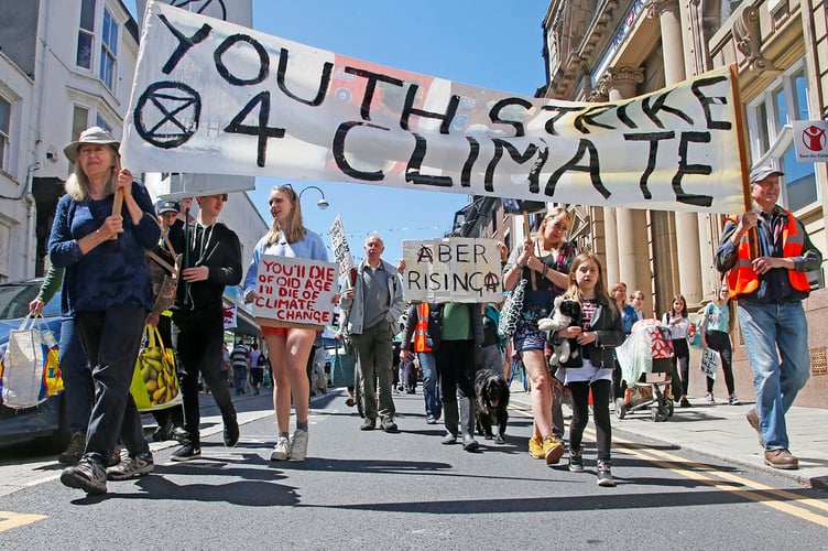 AB2706 CLIMATE97 PHOTO CODE 19DPJ27JUN97 - PHOTO DAVID ARWYN PARRY JONES / CAMBRIAN NEWS PRESS PHOTOGRAPHER - 27JUNE2019 - REF Chris; YOUTH STRIKE 4 CLIMATE ABERYSTWYTH 21 JUNE - Protest against climate change march in Aberystwyth last Friday. - Itinerary - All school children will have gathered in front of the train station by 12pm and we will stay here for 15/20 minutes to shout, chant and chalk the pavements. This is a good spot to meet us if you are coming from anywhere else as its right by the bus and train station. - Walk towards Rummers bar, then turn right up the road towards the clock tower. - Everyone will have arrived at the clock tower where we will gather for roughly 15 minutes to chant, chalk and cover the street in posters highlighting the climate issue. - We will walk down the street and we will stop at the bottom of the road by Barclays to stage a short die-in on the pavement. A die-in is when everyone lies down on the floor silently pretending to be dead, this looks very dramatic and effective! We might also be supported outside Barclays by a peaceful Buddhist group (still being planned) - Then we will jump up again and continue to chant and march all the way down to the Morrisonâs round about where we will walk around the roundabout. - And then lastly we will walk to the council buildings where we will stay for the rest of the day until 3pm with all sorts going on including: Â· Face painting Â· Poster &sticker making Â· Seed bombing . Chalking Â· Food will be provided Â· Peoples assembly Â· Aerial hoop performers Â· Possibility of George Monbiot doing a talk (still being arranged but fingers crossed) Â· Litter picking Â· Lots of shouting, chanting, dancing, sitting, eating, laughing (etc)
Regards, Youth Strike 4 Climate Aberystwyth. - PHOTO - Protesters