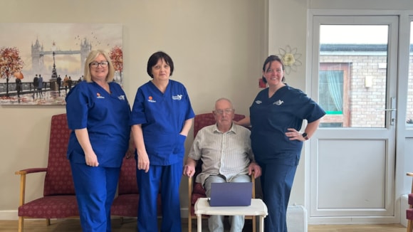 A resident with members of the team from Awel Tywi Residential Home using the newly installed superfast fibre wifi.