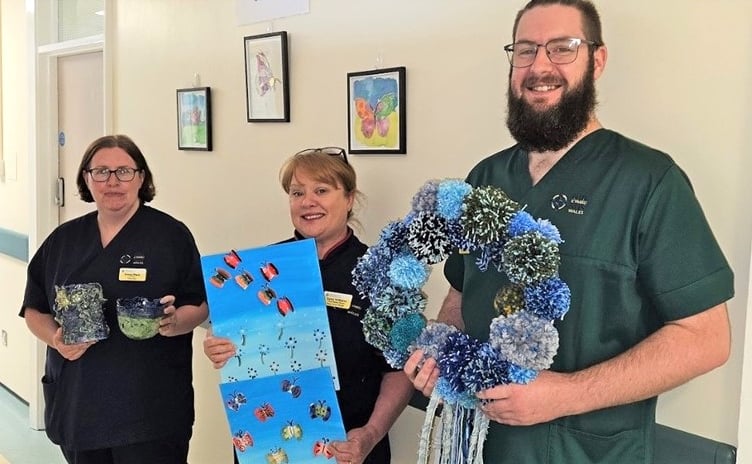 Hywel Dda staff with craftwork made by patients taking part in arts activities